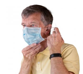 Senior caucasian man adjusting his face mask and looking very tense and concerned about coronavirus epidemic. Isolated against white