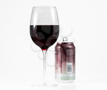 Aluminum can of California Pinot Noir behind a full glass of red wine showing move to single serving cans