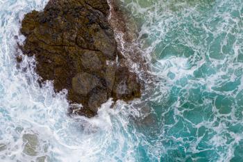 Drone aerial view of waves crashing over rocks on Lumaha'i beach on north shore of Kauai