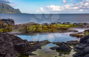 Long exposure of the calm waters of Queen's Bath, a rock pool off Princeville on north shore of Kauai