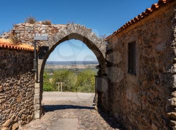 Old stone wall and arch around the houses and narrow streets in the ancient town of Castelo Rodrigo in Portugal