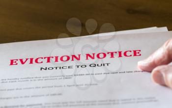 Defaulting renter with letter giving notice of eviction from home on table with copy space