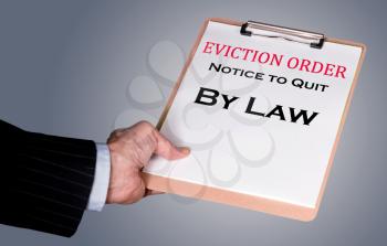Man in suit serving an eviction notice to a defaulting renter in due to missed rent in recession