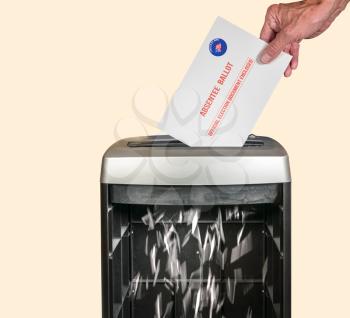 Absentee ballot voteing by mail envelope being shredded in office paper shredder as concept for voting fraud or lost votes in Presidential election