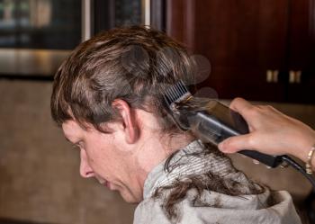 Close up of caucasian man having his hair cut at home during quarantine for coronavirus. Using electric clipper