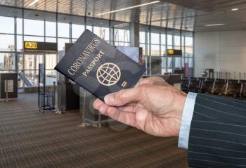 Mockup of airport terminal with businessman hand holding Coronavirus passport showing immunity to covid-19 virus