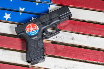 Concept of violence at voting precincts in US presidential election with gun and I Secured the Vote campaign button