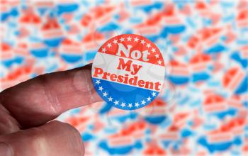 Campaign button or badge on caucasian senior finger stating Not my President in protest against ballot rigging