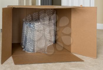 Humorous photo of a small boxed product surrounded by bubble wrap in a large almost empty delivery box