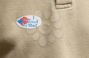I Voted by Mail sticker on mans T-shirt for absentee ballot or mail-in voting in the presidential election during coronavirus pandemic