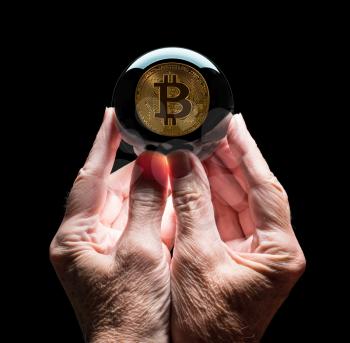 Crystal futures or fortune telling ball reflecting a Bitcoin coin as concept for predicting the future exchange rate for the currency