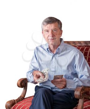 Senior caucasian man holding some US dollar bills as if handing them to the viewer. Isolated against white background
