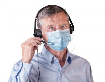 Senior caucasian man wearing facemask using headset to talk to customers or team during coronavirus epidemic. Isolated against white background