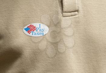 I Pay Taxes sticker on mans T-shirt for anger about the lack of federal tax paid by president in the presidential election