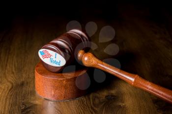 I voted campaign sticker on the mallet by wooden gavel to illustrate the concept of judges overruling the rights of voters in the election