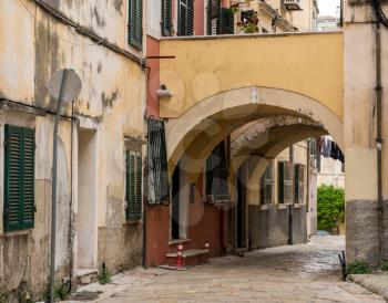 Narrow street with arch between homes in Kerkyra