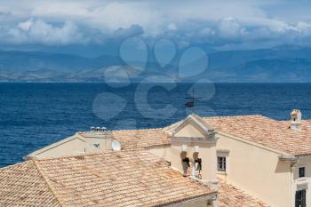 Tiled roof and bell tower of old building by Faliraki beach in Kerkyra