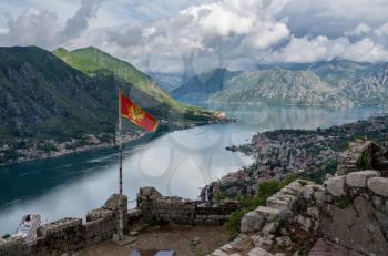 Aerial view of Dobrota and Kotor from hike to Fortress with Montenegro national flag