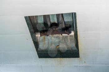Close view of heavy steel anchor on the side of a white ship