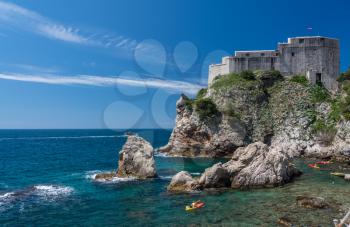 Kayakers or canoeists in the sea by the old fort Lawrence in Dubrovnik