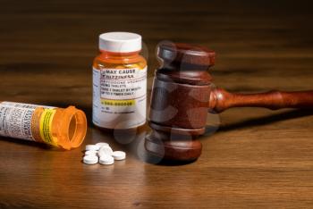 Oxycodone is the generic name for opoid pain killing tablets. Prescription bottle for pills and tablets with judge's gavel for court decision