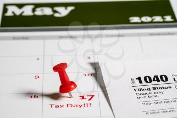 Calendar with Tax Day note inserted in the date for May 17 to illustrate the new tax return filing date of 17th May 2021.