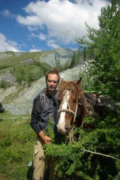 Orlov village, Altai, Russia - June 29, 2016: People with horses Horses walk and graze