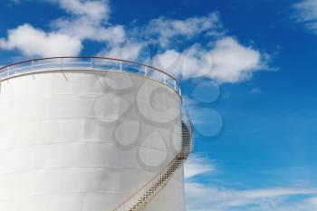Industrial fuel tank against blue sky background
