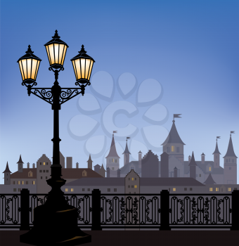 Night cityscape with luminous street lantern. Old street light in european town with castle on background.