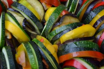 Ratatouille. Vegetable dish. Peasant food. Vegetables, cut into slices. Zucchini, pepper, tomato, eggplant. Kitchen. Recipes. Delicious. It is useful. Close-up. Horizontal photo