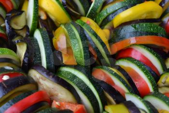 Ratatouille. Vegetable dish. Peasant food. Vegetables, cut into slices. Zucchini, pepper, tomato, eggplant. Kitchen. Recipes. Delicious. It is useful. Close-up. Horizontal