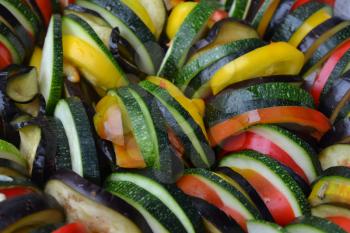 Ratatouille. Vegetable dish. Peasant food. Vegetables, cut into slices. Zucchini, pepper, tomato, eggplant. Kitchen. Recipes. It is useful. Close-up. Horizontal photo
