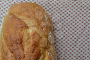 Bread. A loaf of bread. Freshly baked bread. Tablecloth. Delicious. Kitchen. Close-up. Horizontal photo