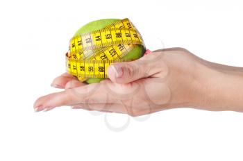 Measuring tape and fresh green apple in hands as a symbol of diet