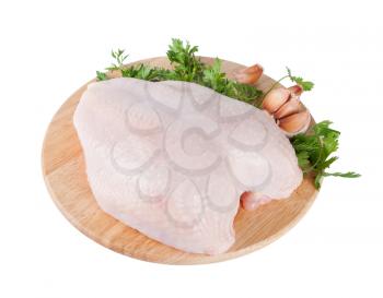 Raw chicken breast on board with parsley and garlic