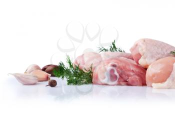 Raw chicken legs with garlic cloves and dill on a white background