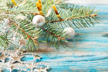 Silver Christmas decorations and fir branch on a blue wooden background