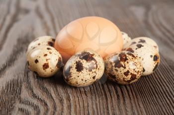 Quail and chicken eggs on a wooden table