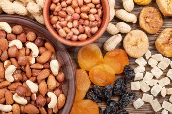 Different nuts and dried fruits on a wooden table. Almond, hazelnut, peanuts and cashew. Background with nuts and fruits.