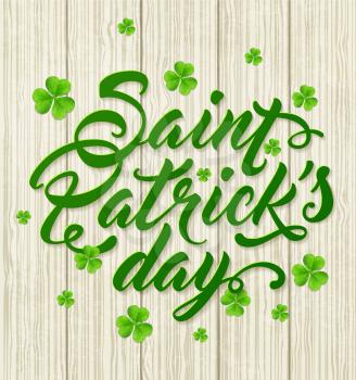 Lettering and green clover leaves on a wooden background. Greeting card for St. Patrick's Day