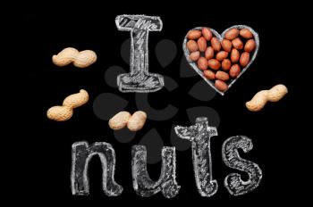 Peanuts on a black background and chalk inscription I love nuts