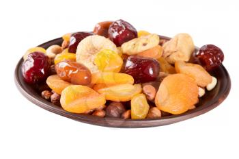 Dried fruits isolated on a white background. Dates, lemon, apricots, figs and nuts in a clay plate. 