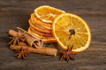 Dried orange slices, cinnamon and star anise on a brown wooden background. Spices for mulled wine and winter decoration. 