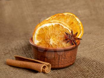 Dried orange slices, cinnamon and star anise on a sacking texture background. Spices for mulled wine.