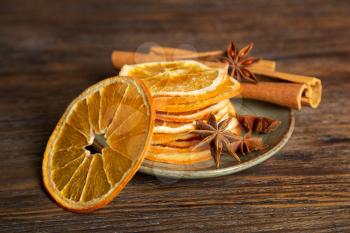 Dried orange slices, cinnamon and star anise on a brown wooden background. Spices for mulled wine.