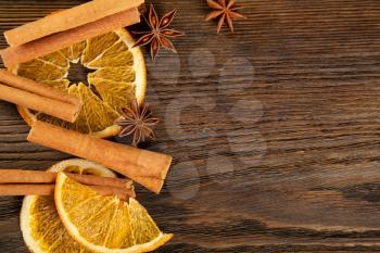 Dried orange slices, cinnamon and star anise on a brown wooden background. Spices for mulled wine. Top view