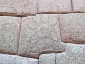 Inca wall made of natural volcanic stones, perfectly shaped, heritage of Inca history and architecture in Cusco, Peru.