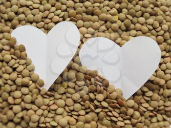 White Heart shape on Heap of raw lentils background