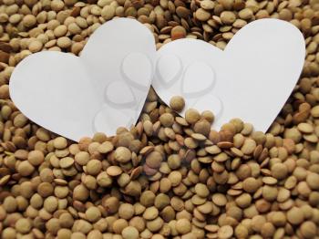 White Heart shape on Heap of raw lentils background
