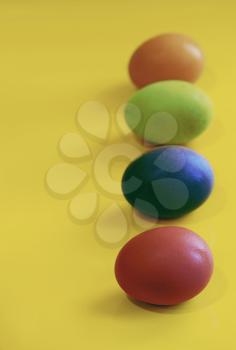 A simple laconic picture with Easter eggs arranged in a row one after another on a yellow background